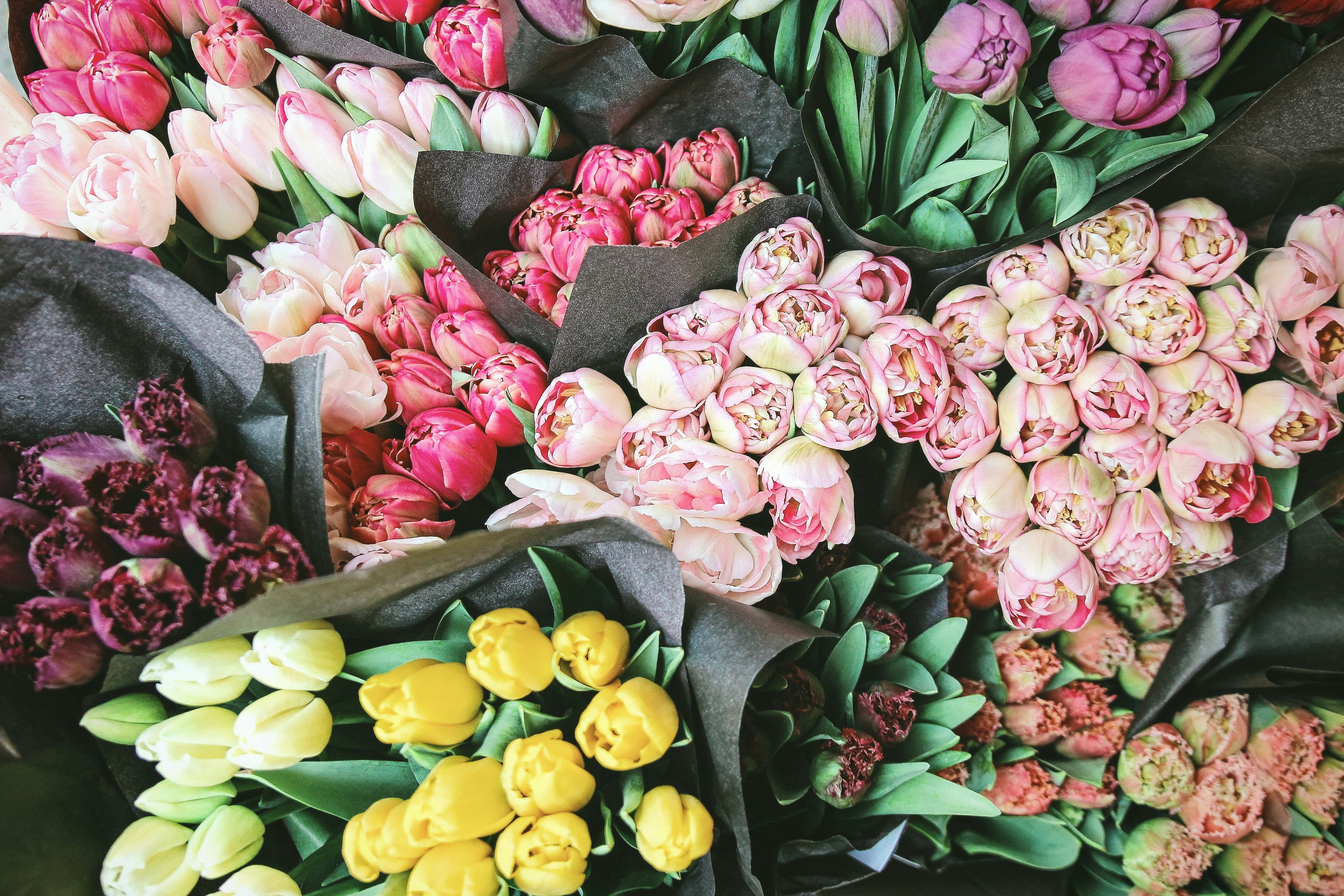 Tulipanes y rosas de colores variados en un mercado de flores